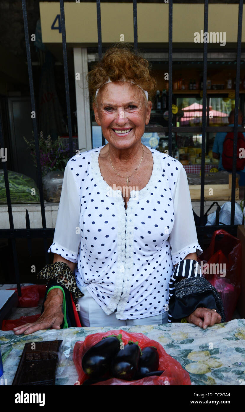 La colorata Kotor mercato agricolo, sotto le sue mura medievali. Foto Stock