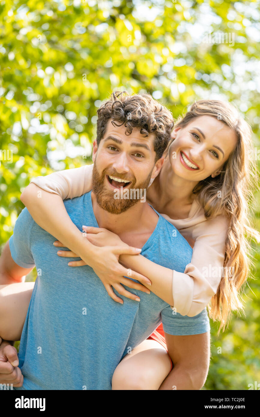 Il marito è portando la sua moglie sulla sua schiena essendo un partner affidabile Foto Stock