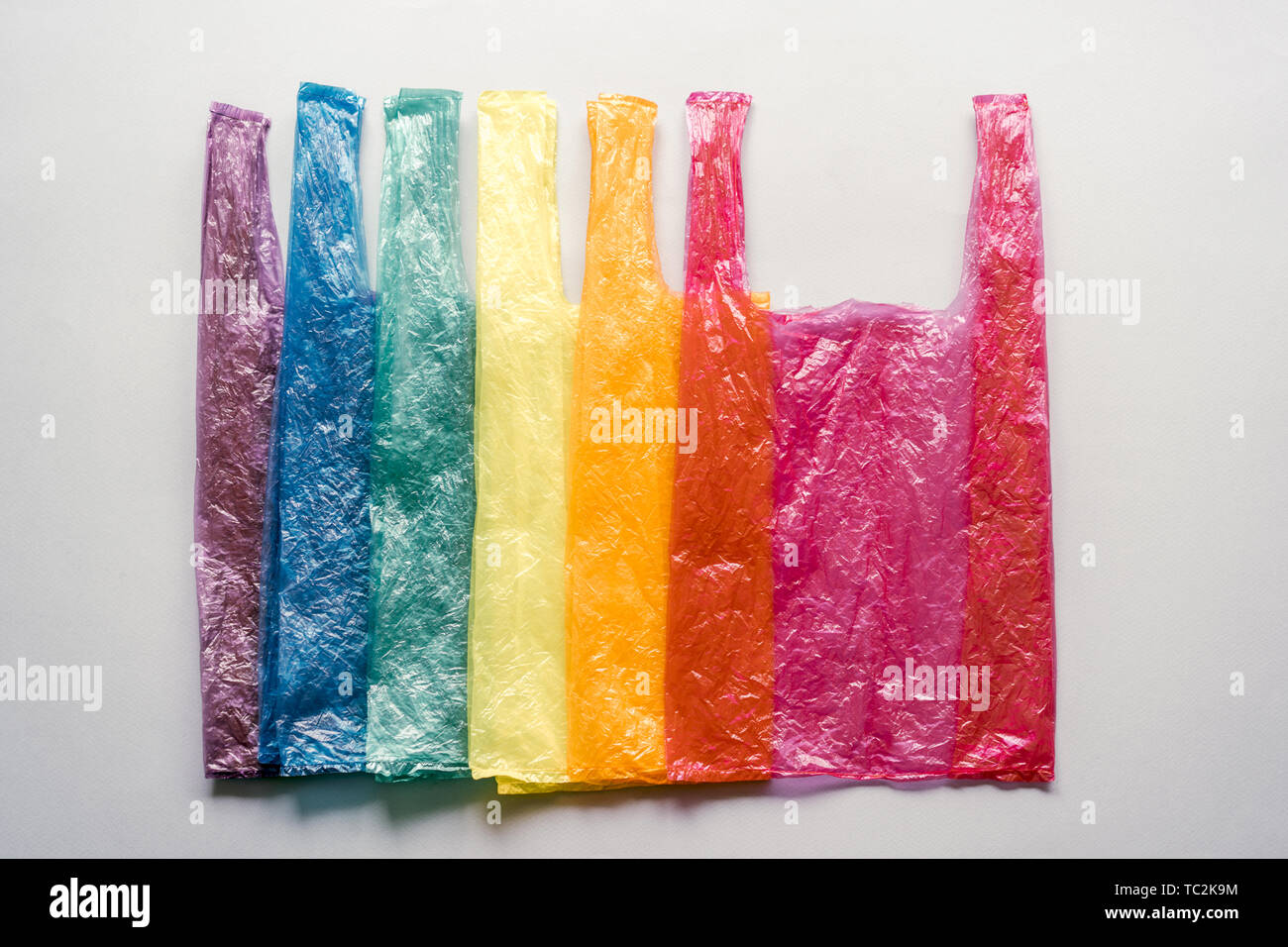 Sacchetti di plastica impilate nei colori dell'arcobaleno. Ecologia promemoria. Società di consumo. Immagine concettuale. Foto Stock