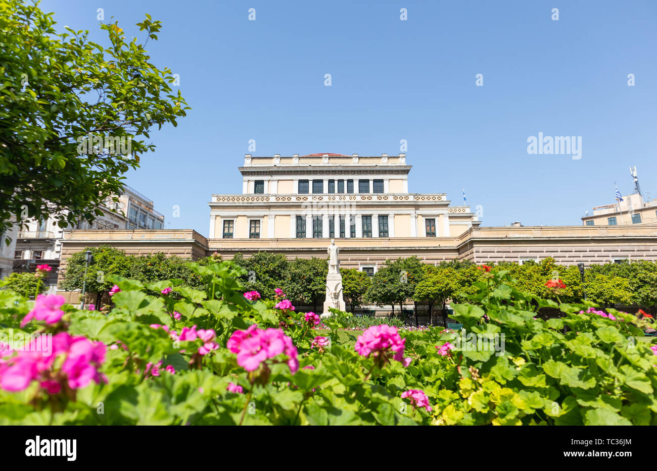 Aprile 28, 2019. Atene, Grecia. Statua di Charilaos Trikoupis nella parte anteriore del Vecchio Parlamento. Alberi e fiori circondano la scultura bianco. Blue sky bac Foto Stock