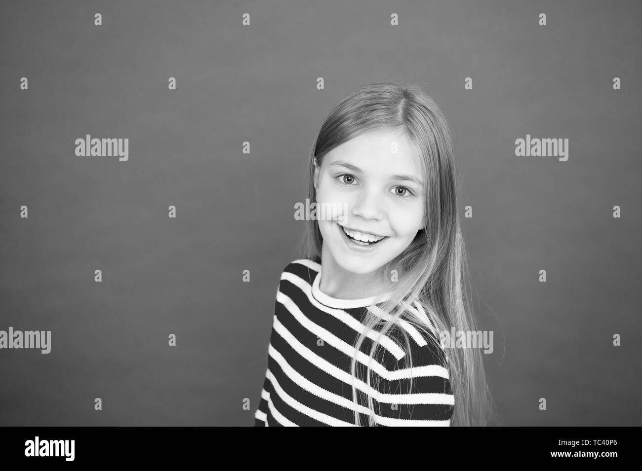 Buona genitorialità. Prodotti per la cura del bambino. La famiglia e l'amore. giorno. Felice bambina su sfondo rosso. piccole bambine. Istruzione scolastica. Infanzia felicità. copia di spazio. Poco d'evasione. Foto Stock