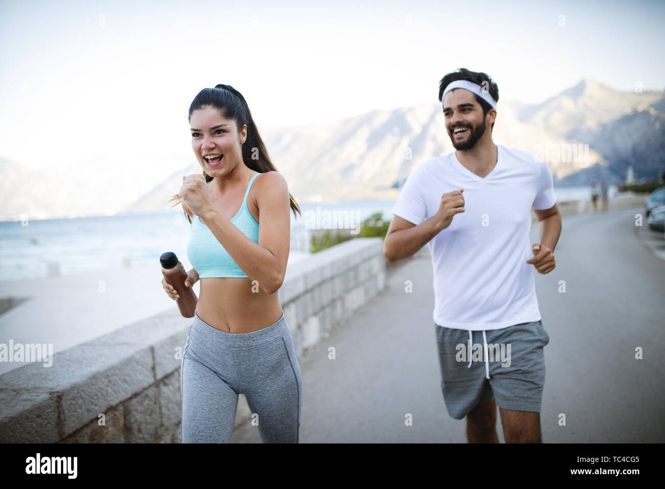 Felice giovani montare la gente giovane in esecuzione per esterno Foto Stock