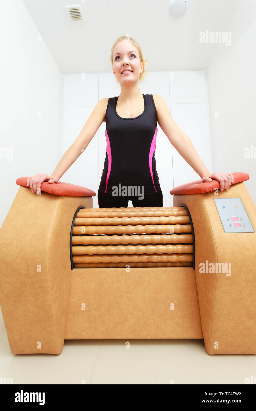 Dermocosmesi, bodycare, il concetto di benessere. Donna di liberarsi di cosce cellulite su grande rotolo macchina. Massaggio sani di trattamento in spa Foto Stock
