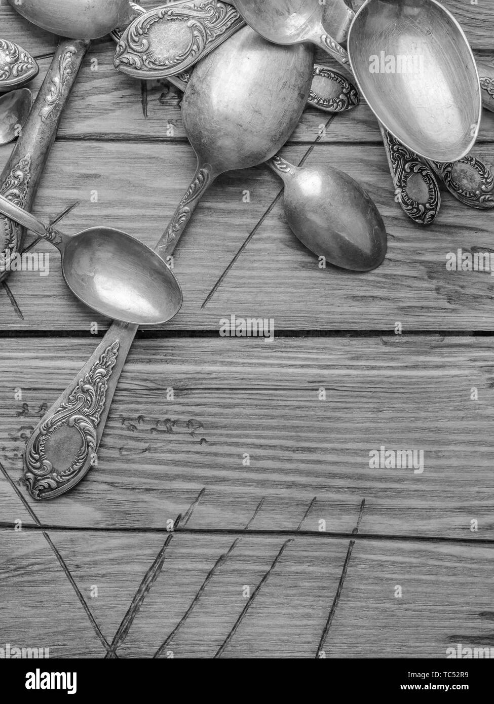 Vecchio vintage ornate posate su un tavolo di legno. foto in bianco e nero Foto Stock