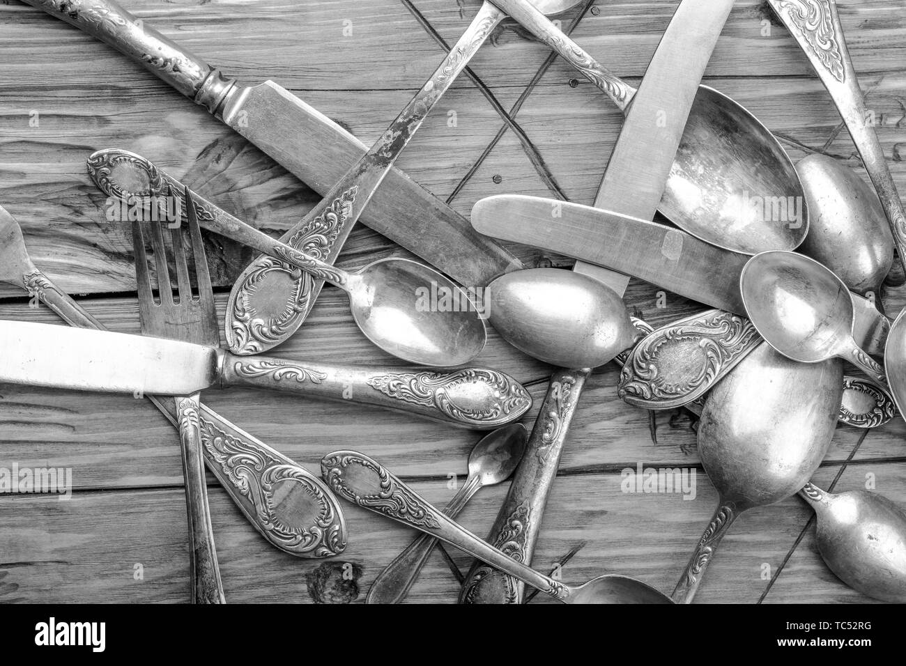 Vecchio vintage ornate posate su un tavolo di legno. foto in bianco e nero Foto Stock