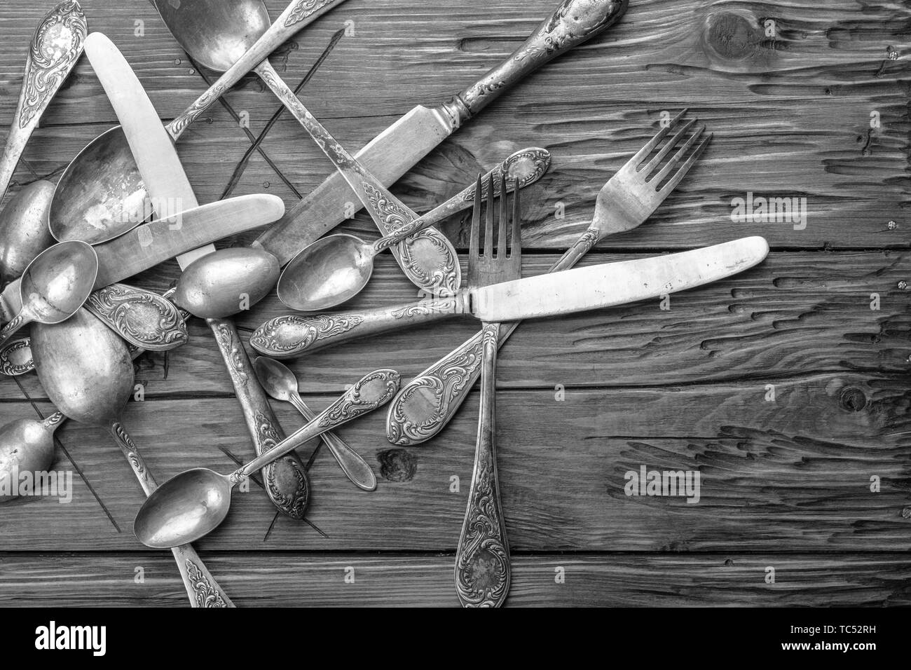 Vecchio vintage ornate posate su un tavolo di legno. foto in bianco e nero Foto Stock