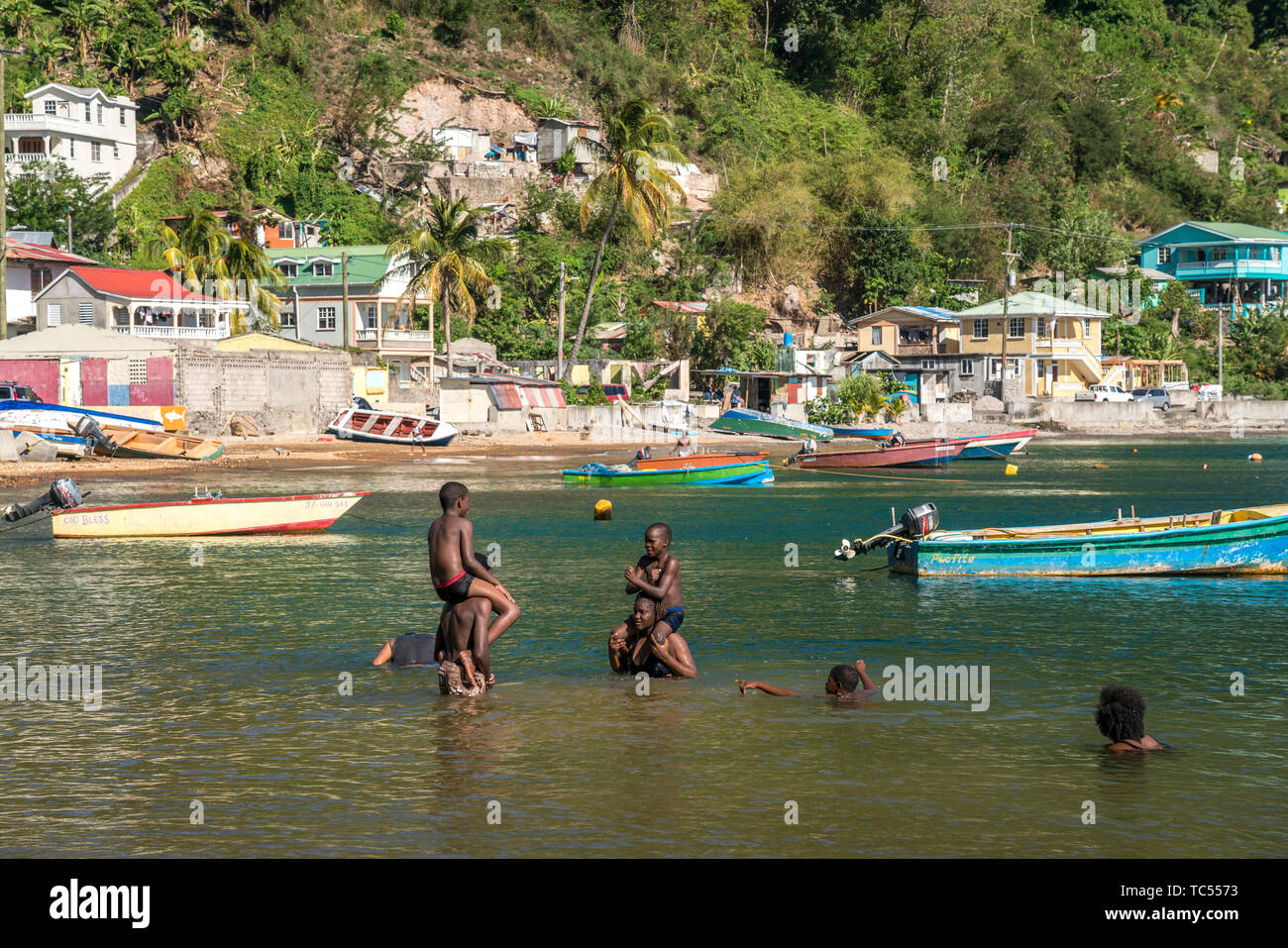 Einheimische baden am Strand von Soufriere, Dominica, Karibik, Mittelamerika | locali per divertirsi in spiaggia in Soufriere, Dominica, Caraibi, Cen Foto Stock