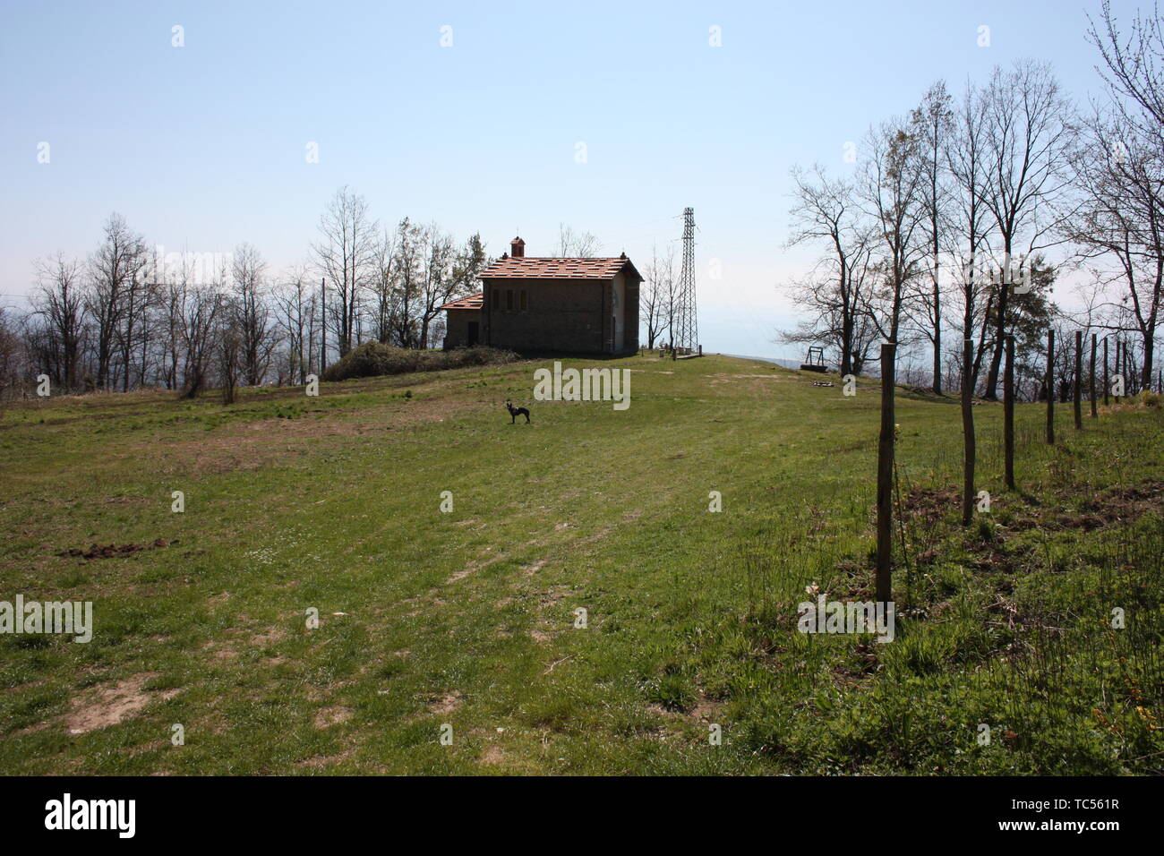 Piccola chiesa abbandonata, in disuso, sulle Alpi Apuane dell'Appennino Toscano in una radura su una soleggiata giornata di primavera Foto Stock