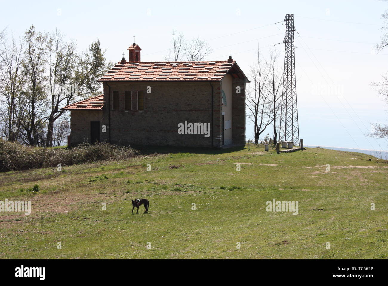 Piccola chiesa abbandonata, in disuso, sulle Alpi Apuane dell'Appennino Toscano in una radura su una soleggiata giornata di primavera Foto Stock