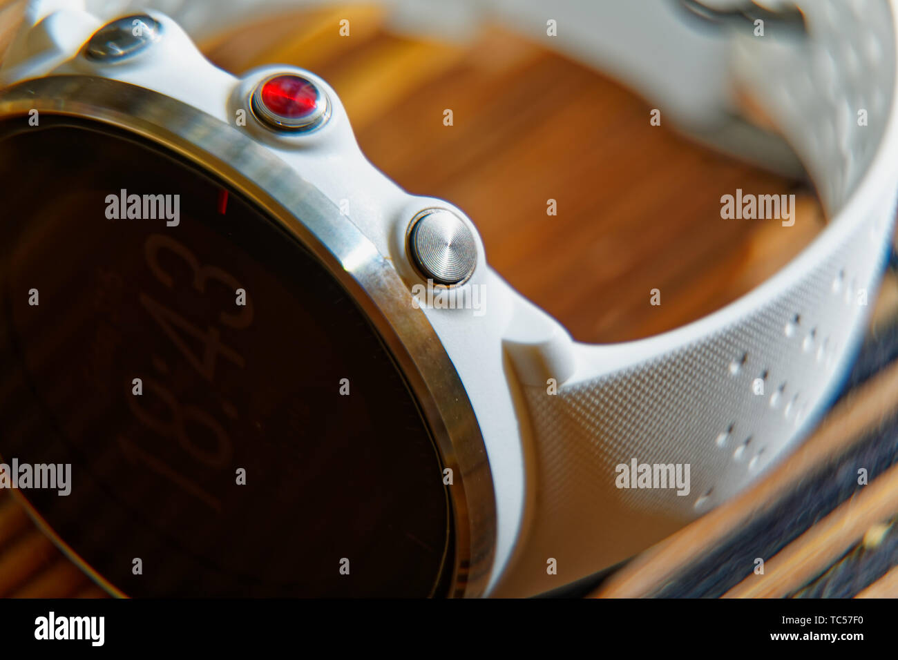 Orologio sportivo di colore bianco e rosso pulsante sul tavolo di legno, orologio intelligente per correre e allenamento di fitness Foto Stock