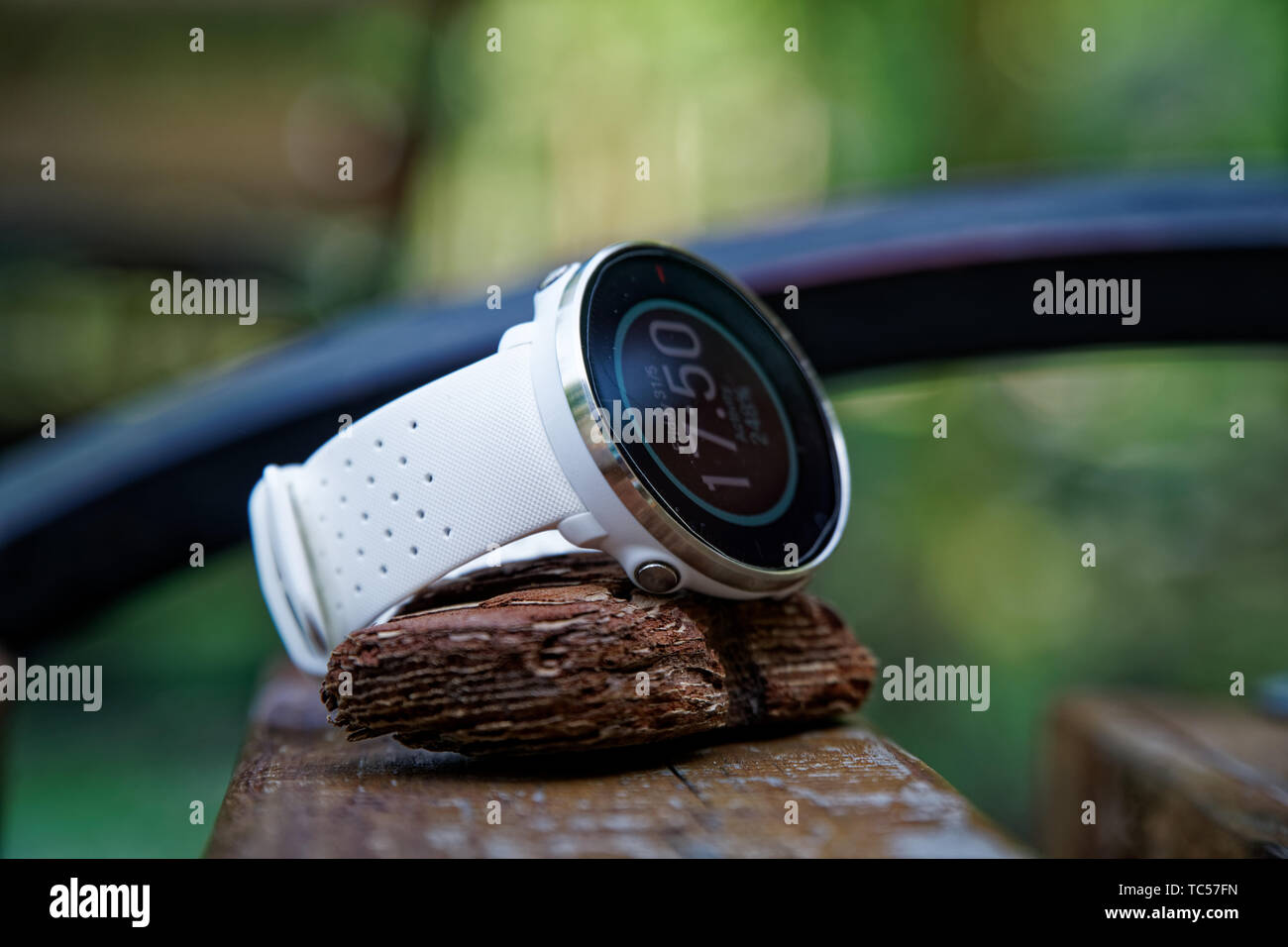 Close-up sport watch per l'esecuzione di colore bianco sul banco di legno. Orologio fitness per tenere traccia delle attività quotidiane e di allenamento di potenza Foto Stock