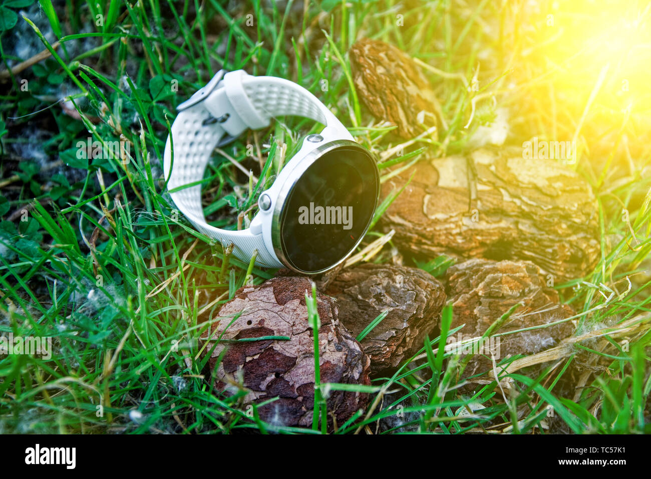 Sport watch per l'esecuzione di colore bianco sul terreno in erba. Orologio fitness per tenere traccia delle attività quotidiane e la forza di formazione Foto Stock