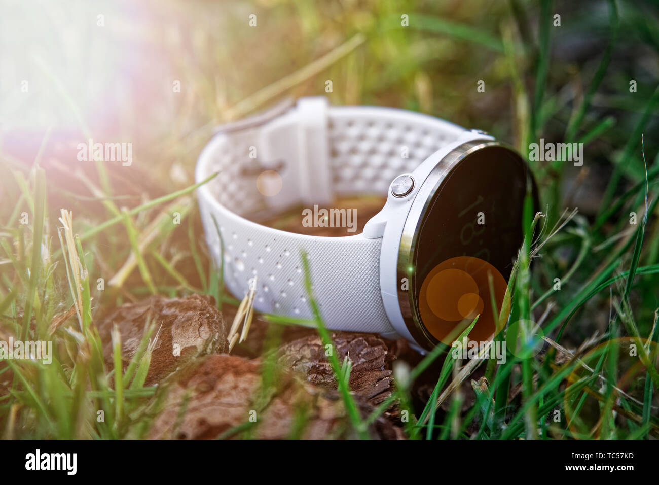 Sport watch per l'esecuzione di colore bianco sul terreno in erba. Orologio fitness per tenere traccia delle attività quotidiane e la forza di formazione Foto Stock