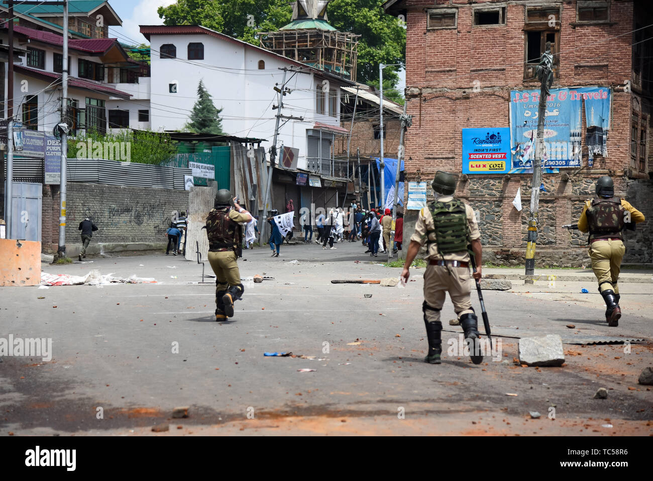 Un poliziotto indiano visto sparare proiettili verso i manifestanti durante gli scontri a Srinagar. Le forze indiane in Srinagar usato gas lacrimogeni fumogeni e proiettili per disperdere centinaia di manifestanti che hanno preso a strade dopo Eid-ul-Fitr preghiere per protestare contro la regola di indiana nella regione. Foto Stock