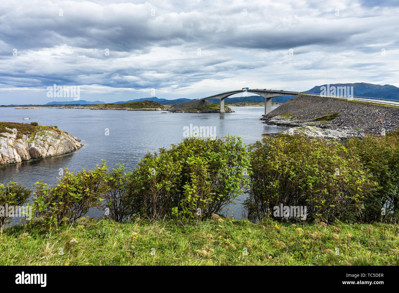 Il bus seguita da auto al vertice del ponte Storseisundet, il più famoso ponte della strada atlantica, Norvegia Foto Stock