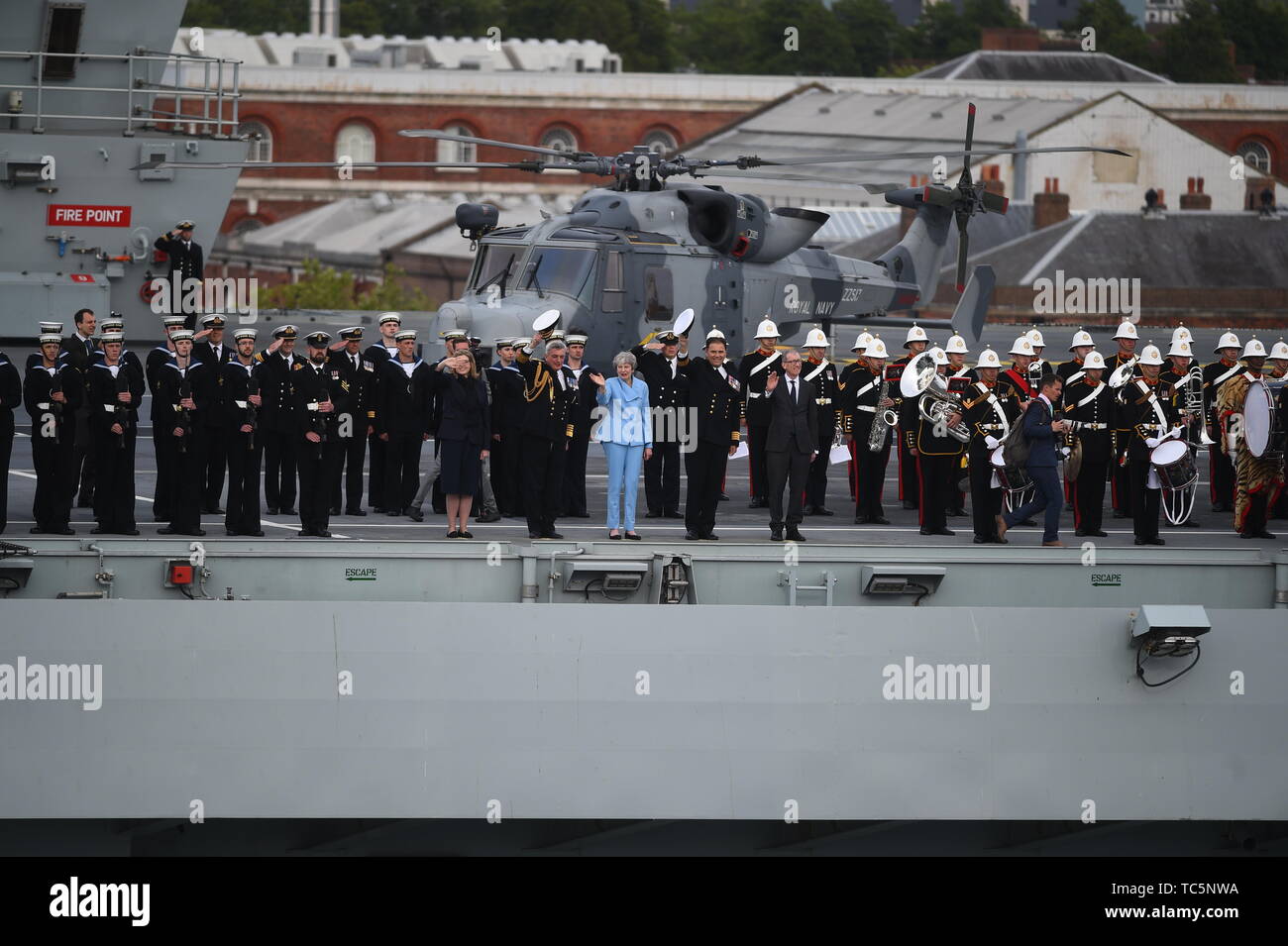 Il Segretario della Difesa Penny Mordaunt (sinistra) primo signore del mare e capo del personale navale Ammiraglio Sir Philip Jones e il Primo Ministro Theresa può stazionare sul ponte della HMS Queen Elizabeth come essi onda veterani off a bordo della MV Boudicca, come le vele al di fuori del porto di Portsmouth per lui il porto di Le Havre in Francia come parte delle commemorazioni per il settantacinquesimo anniversario dello sbarco in Normandia. Foto Stock