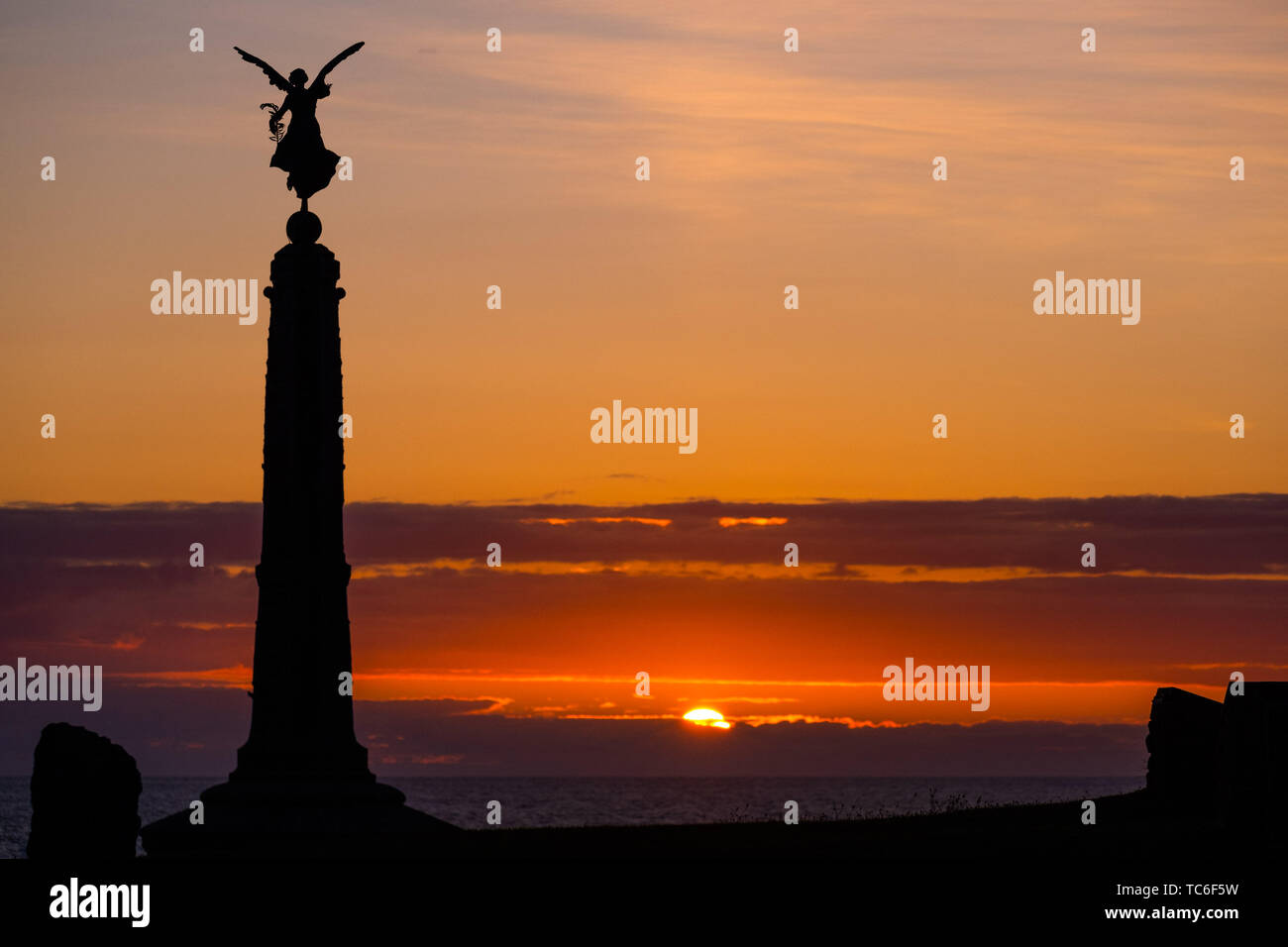 Aberystwyth Wales UK, mercoledì 05 giugno 2019 UK Meteo: il sole tramonta drammaticamente dietro la silhouette distintivo dell'angelo alato di pace sulla cima di Aberystwyth punto mare del memoriale di guerra sulla West Wales coast. Il clima è destinato a diventare sempre più ly wet nei prossimi giorni con alcune aree vedendo significative quantità di pioggia che conduce al potenziale allagamento Photo credit: Keith Morris / Alamy Live News Foto Stock