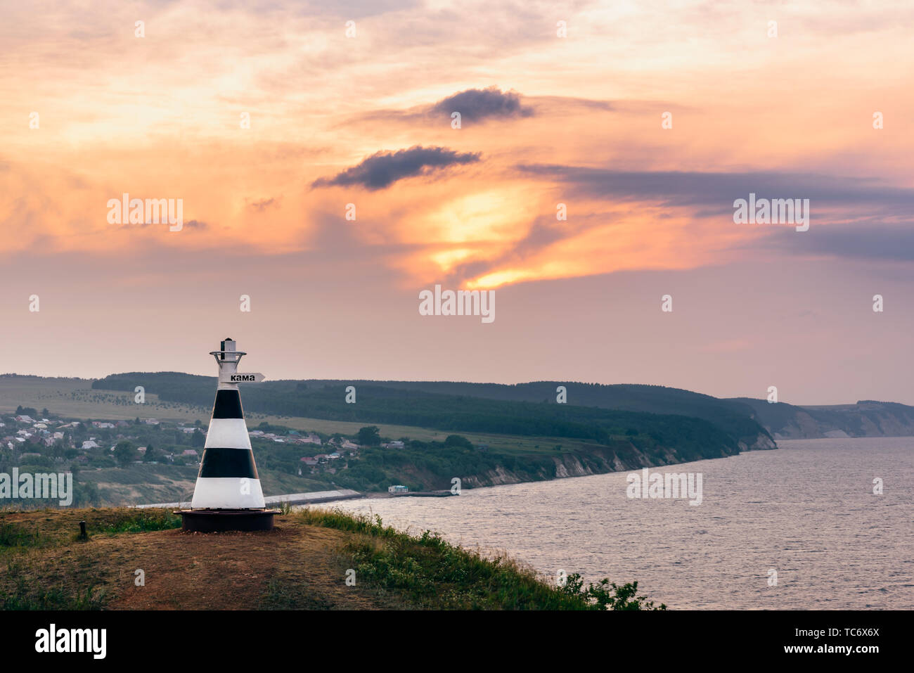 Faro con la scritta 'Kama' sulla collina nella luce del tramonto Foto Stock