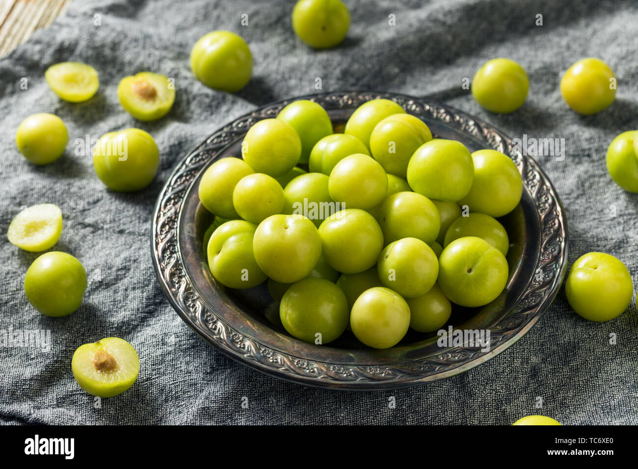 Materie organiche verde Sour prugne in una ciotola Foto Stock