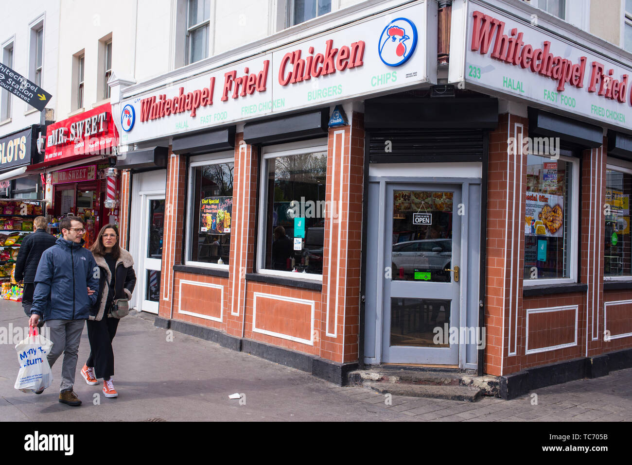 Whitechapel, London, England, Regno Unito - Aprile 2019: Whitechapel fritto di pollo shop con gente che cammina in fornt di esso su Whitechapel Road, Shadwell, Londra Foto Stock