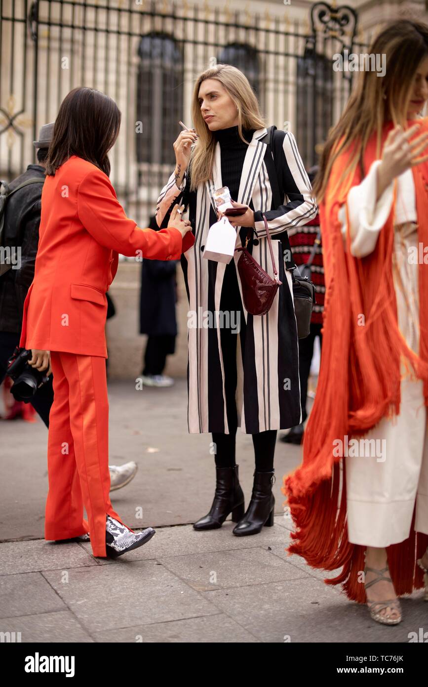 Street Style - Settimana della moda di Parigi per Donna Autunno/Inverno 2019/2020,  Aida Domenech, indossa una tuta arancione e snake stampa stivali da cowboy  e Angela Foto stock - Alamy