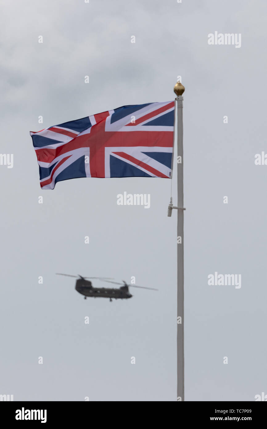 Un elicottero Chinook battenti dietro un'unione jack flag su un pennone Foto Stock