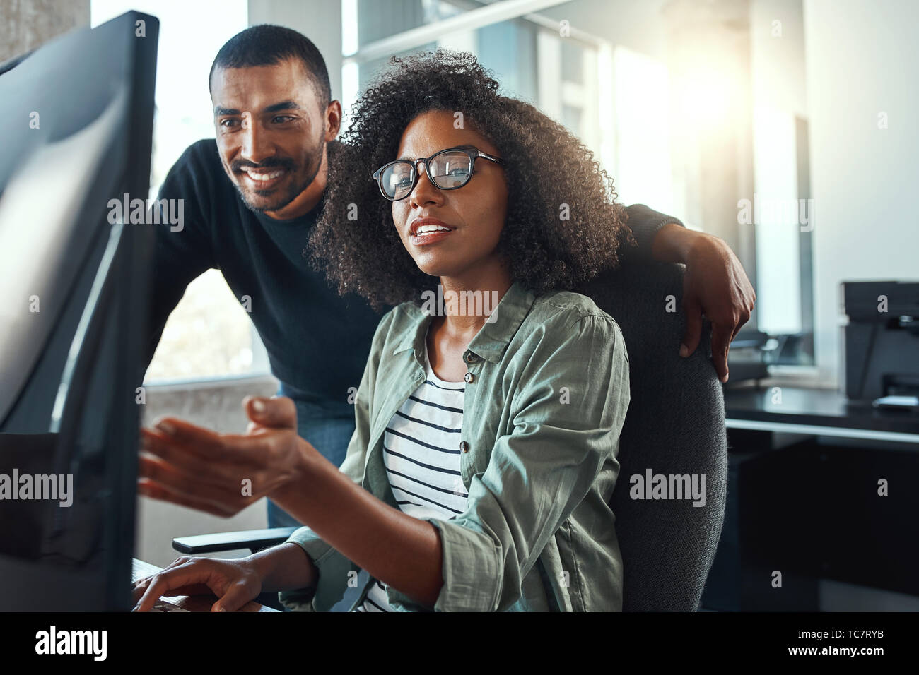 Imprenditrice mostrando qualcosa al suo collega sul computer Foto Stock