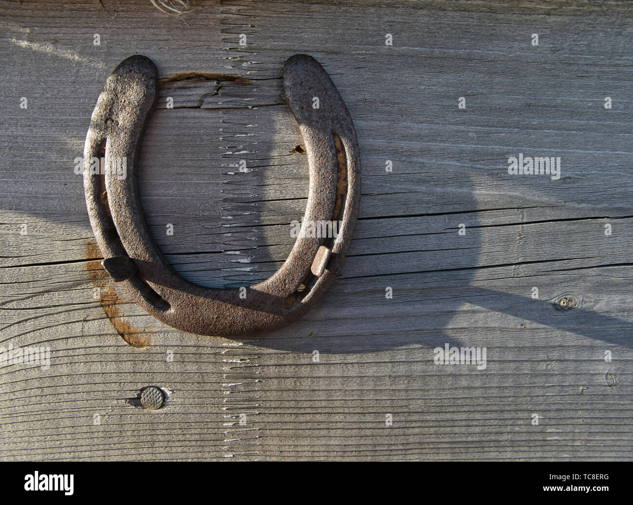Un ferro di cavallo su una tavola di legno è stato probabilmente utilizzato  come portafortuna al di sopra di una porta Foto stock - Alamy