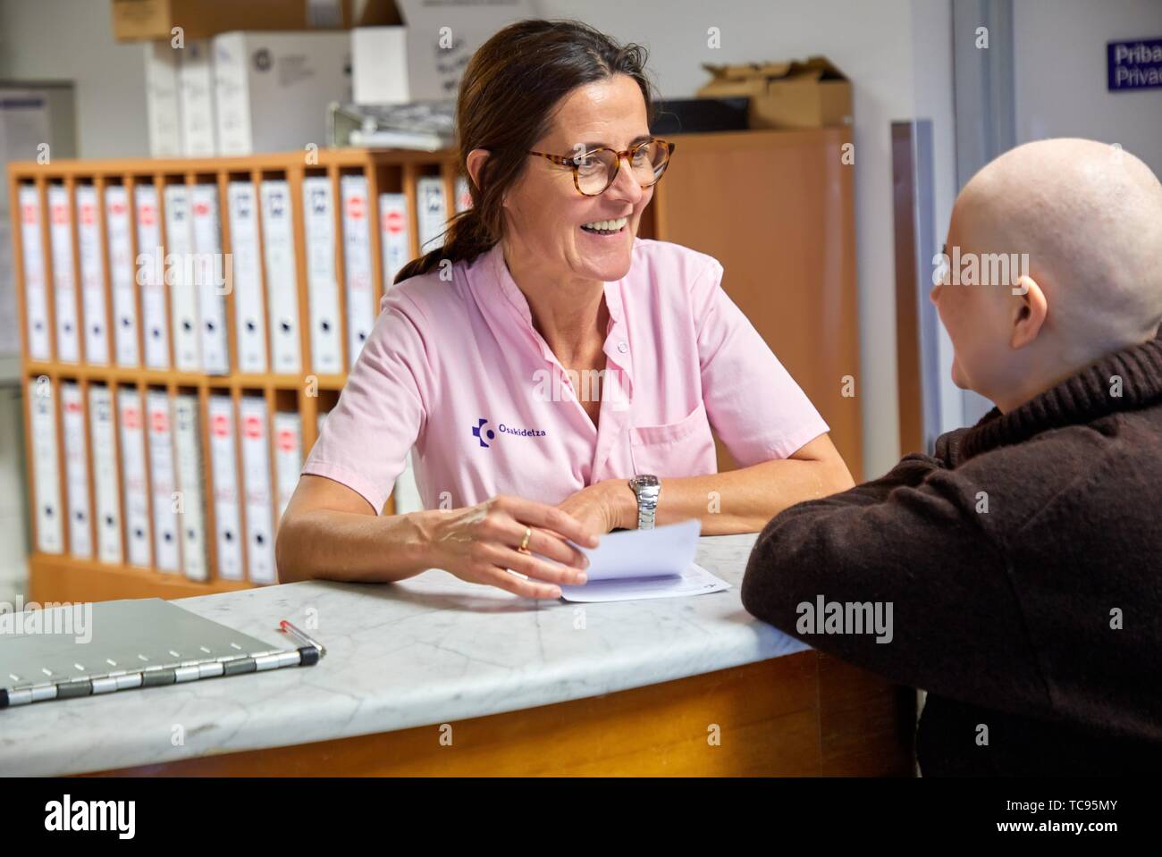 Assistente infermieristica assiste malato di cancro in ospedale reception, Oncologia Ospedale Donostia, San Sebastian, Gipuzkoa, Paesi Baschi Foto Stock