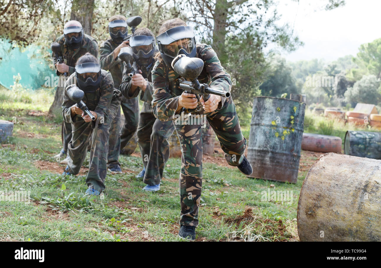 Dynamic paintball battaglia all'esterno. Gruppo di giocatori in piena attrezzatura paintball attaccando squadra opposta Foto Stock