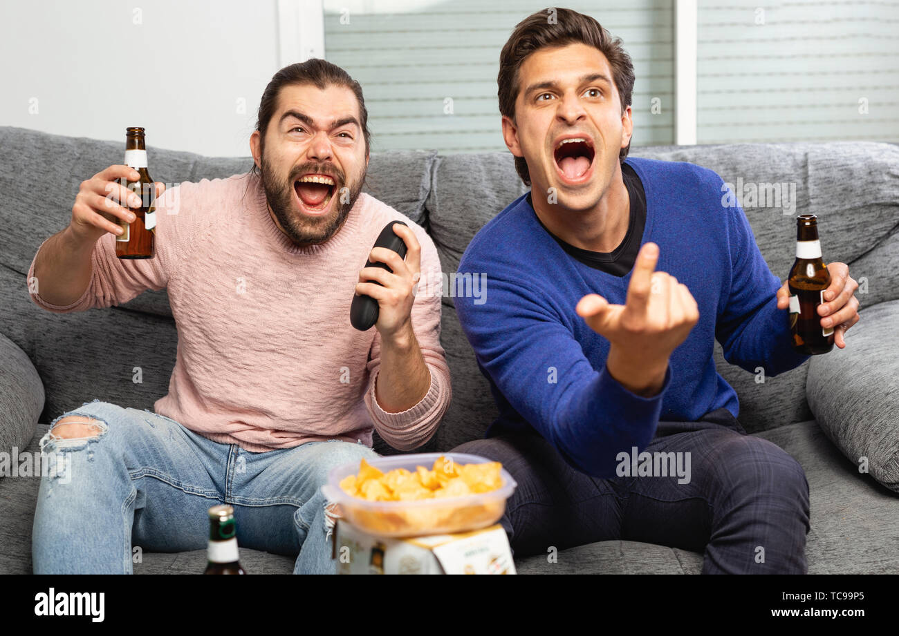 Gli uomini bere birra e guardare la partita in tv Foto Stock