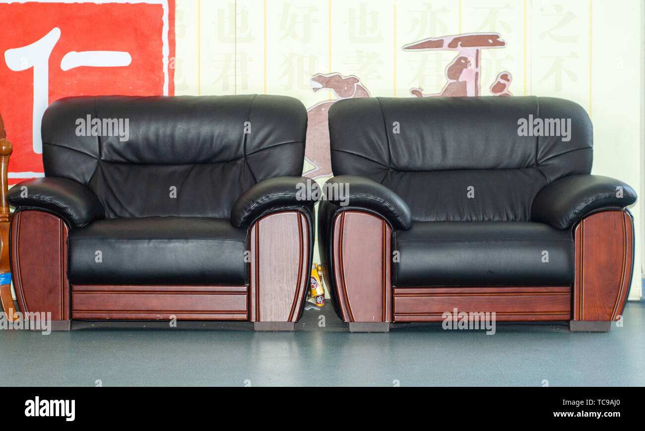 Un mazzetto di divani di pelle nera. Foto Stock