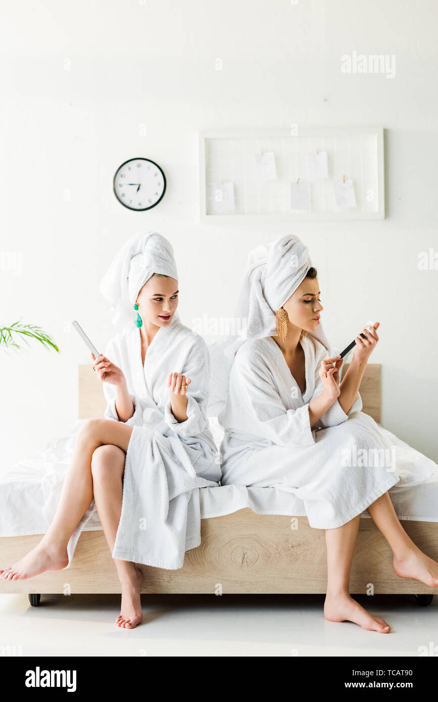 A piedi nudi di donne in accappatoio e gioielli, con asciugamani sulle  testate servendosi di lime per unghie mentre è seduto sul letto Foto stock  - Alamy