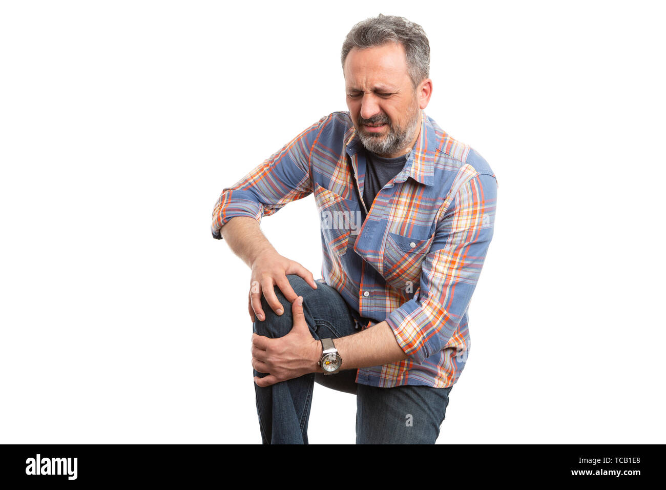 Uomo che fa in espressione di dolore tenendo il ginocchio doloroso come sforzo fisico concetto isolato su bianco di sfondo per studio Foto Stock
