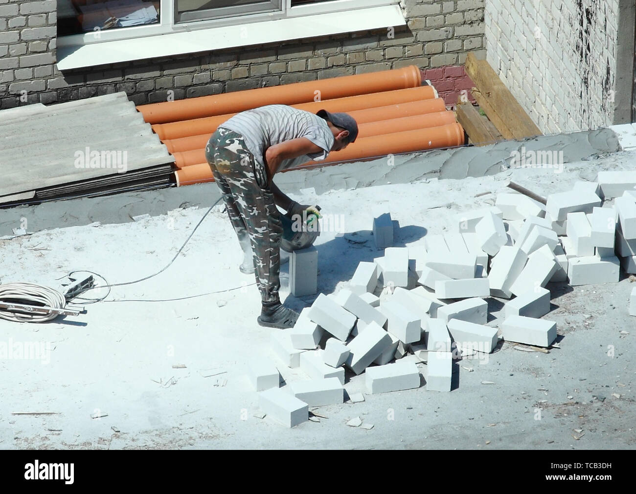 06 05 2019 Russia, Brjansk. Un uomo che lavora con una taglierina taglia un mattone in mezzo. Foto Stock