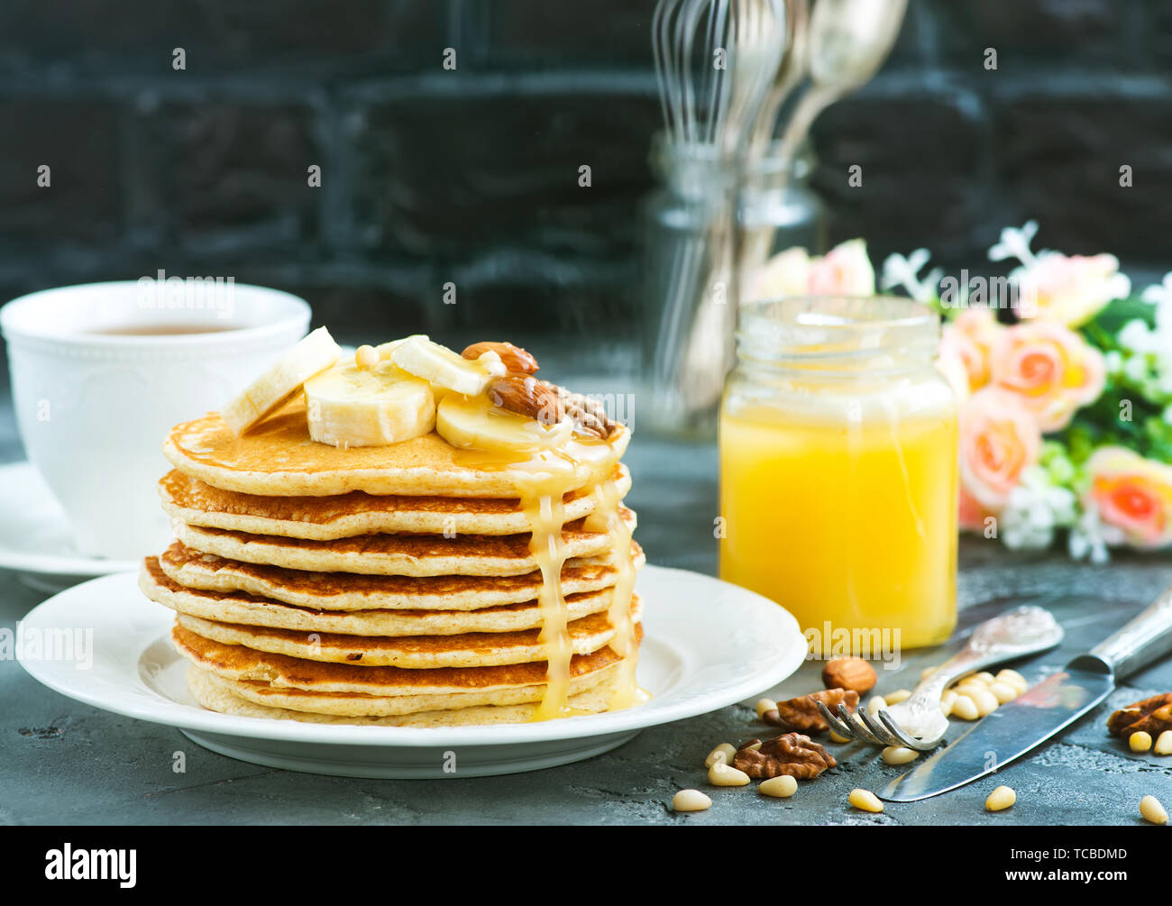 Frittelle con il miele e i dadi sulla piastra Foto Stock