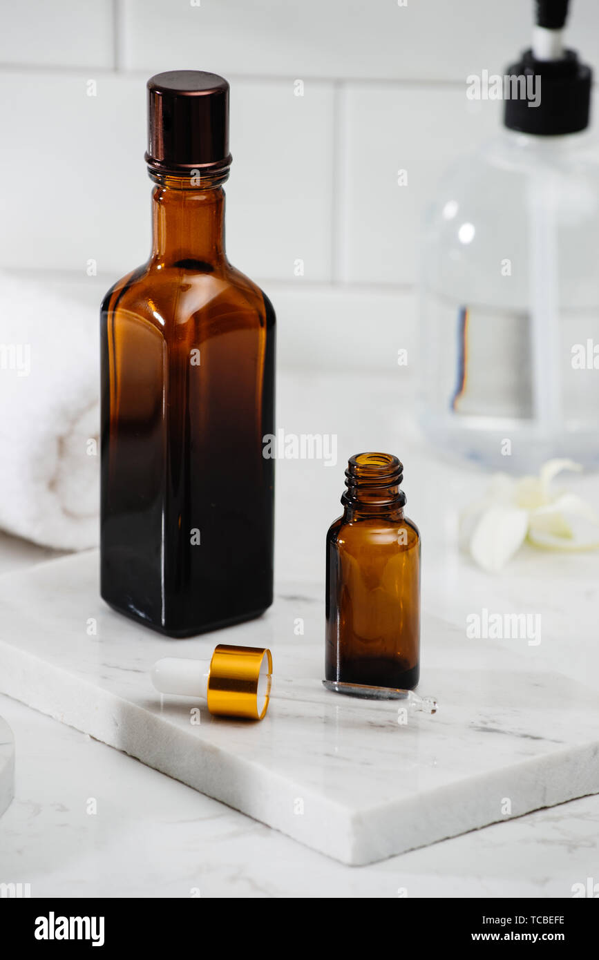 Bottiglie con massaggio oli essenziali, asciugamani e pietre zen. Composizione Spa. Foto Stock