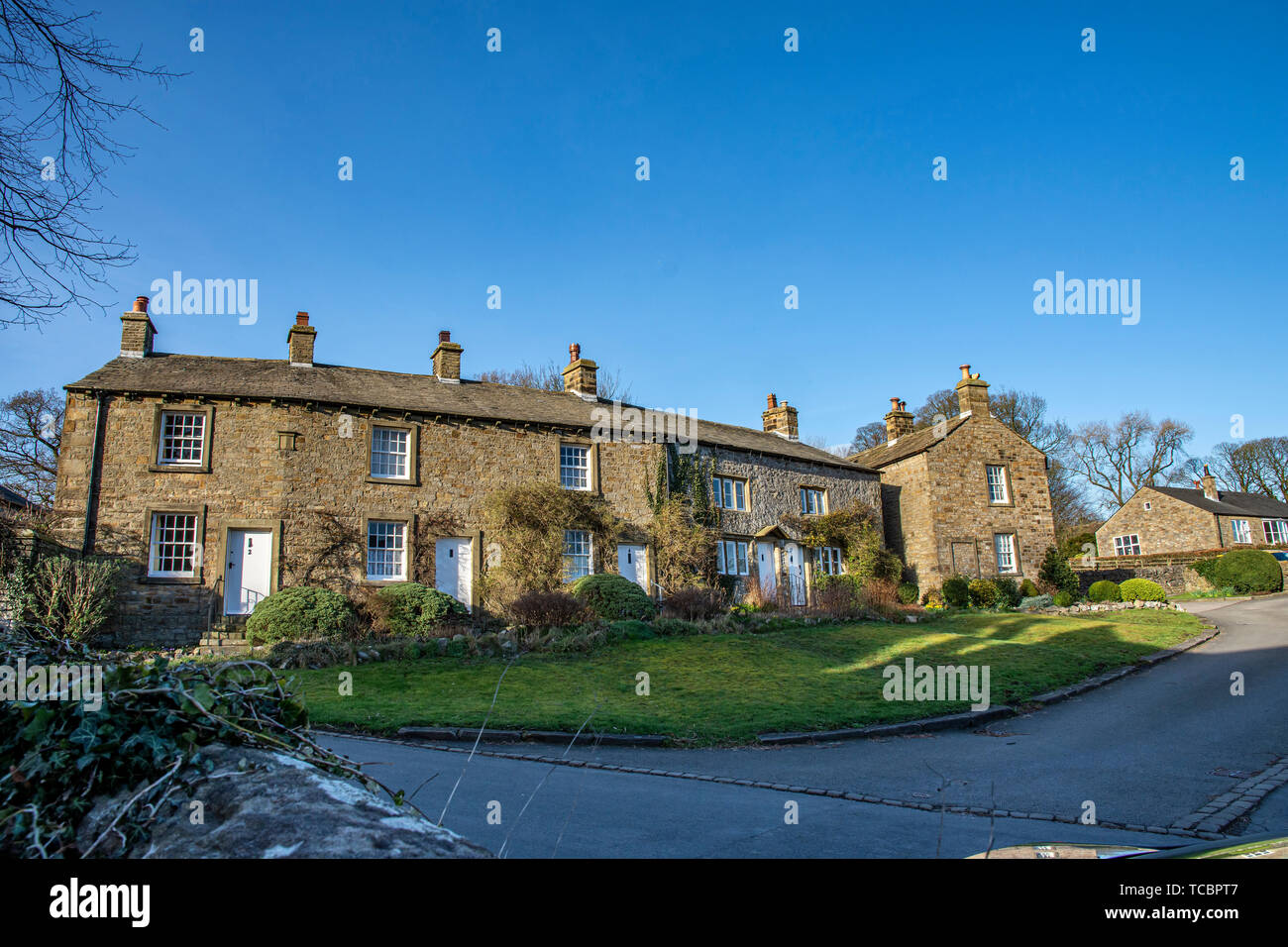 Il pittoresco villaggio di Downham, Lancashire, in serata sole,Ribble Valley, Regno Unito Europa mostra tradizionale cottage in pietra e pareti Foto Stock