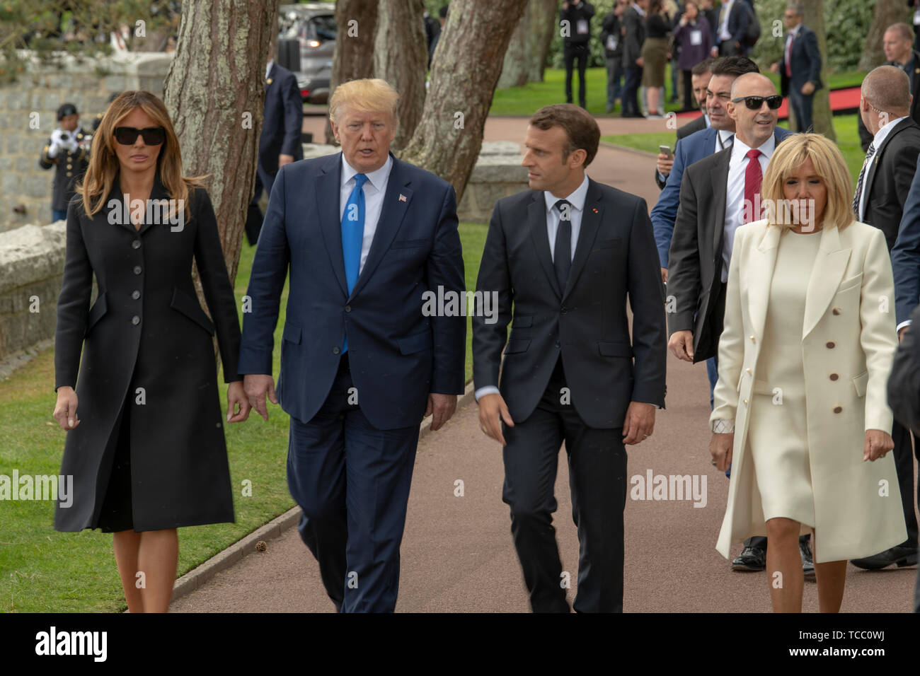 Colleville Sur Mer, Francia. Il 6 giugno, 2019. Stati Uniti Presidente Donald Trump e la First Lady Melania Trump a piedi con il presidente francese Emmanuel Macron e da sua moglie Brigitte Macron per porre fiori su una tomba di un soldato americano durante una cerimonia di commemorazione che segna il settantacinquesimo D-Giorno Anniversario in Normandia Cimitero e memoriale americano a Giugno 6, 2019 in Colleville-sur-Mer, Francia. Migliaia di persone sono confluite in Normandia per commemorare il settantacinquesimo anniversario della Operazione Overlord, la seconda guerra mondiale invasione Alleata comunemente noto come D-Day. Credito: Planetpix/Alamy Live News Foto Stock