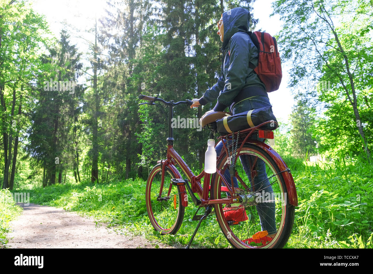 La ragazza sorride felicemente. Passeggiate a cavallo nel parco su una pista ciclabile. Faccia esposta alla luce solare Foto Stock