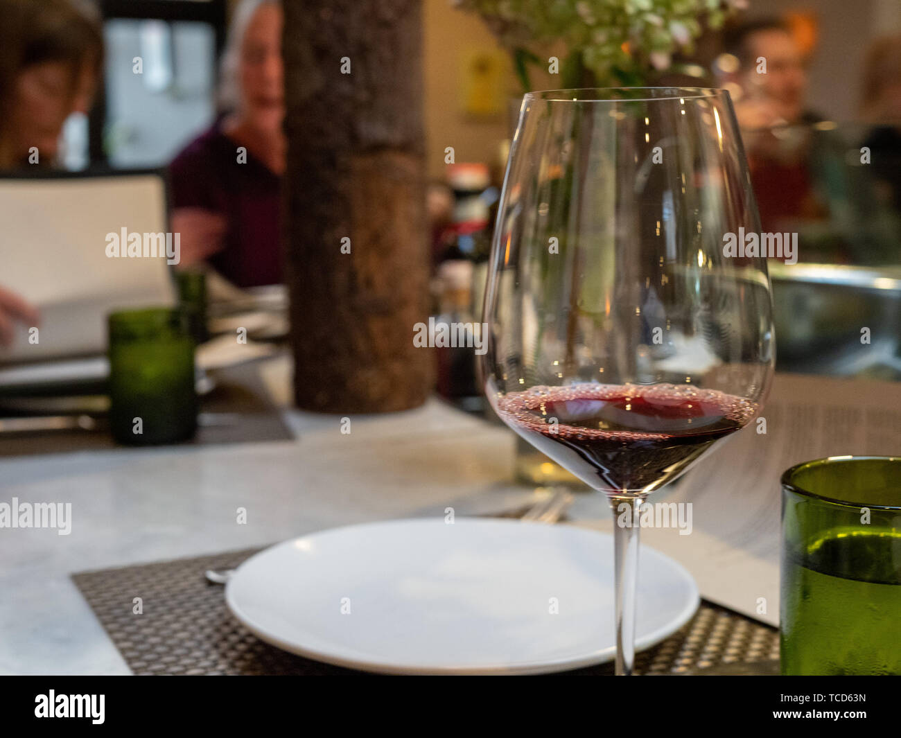 Bicchiere di rosso la degustazione di vino in un ristorante con sala da pranzo mecenati Foto Stock