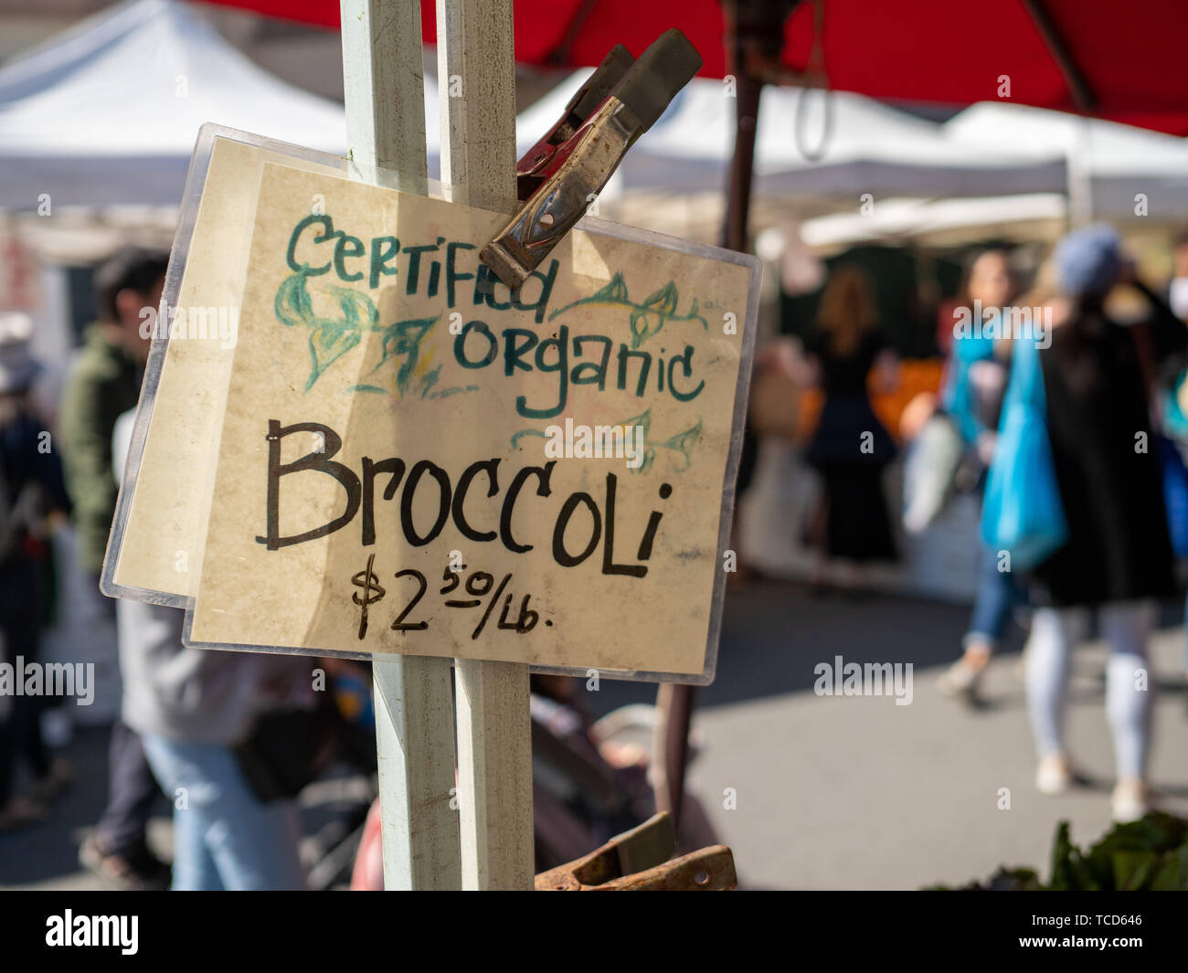 Certificata biologica di broccoli e segno di prezzo appeso su un mercato degli agricoltori tenda Foto Stock