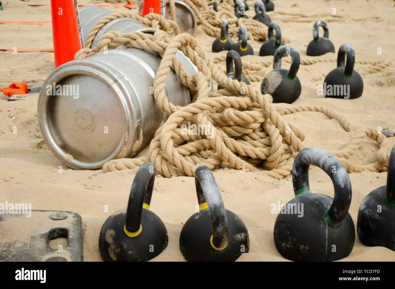 Barile, legato con una corda e dei pesi sulla spiaggia prima di un evento sportivo. Foto Stock