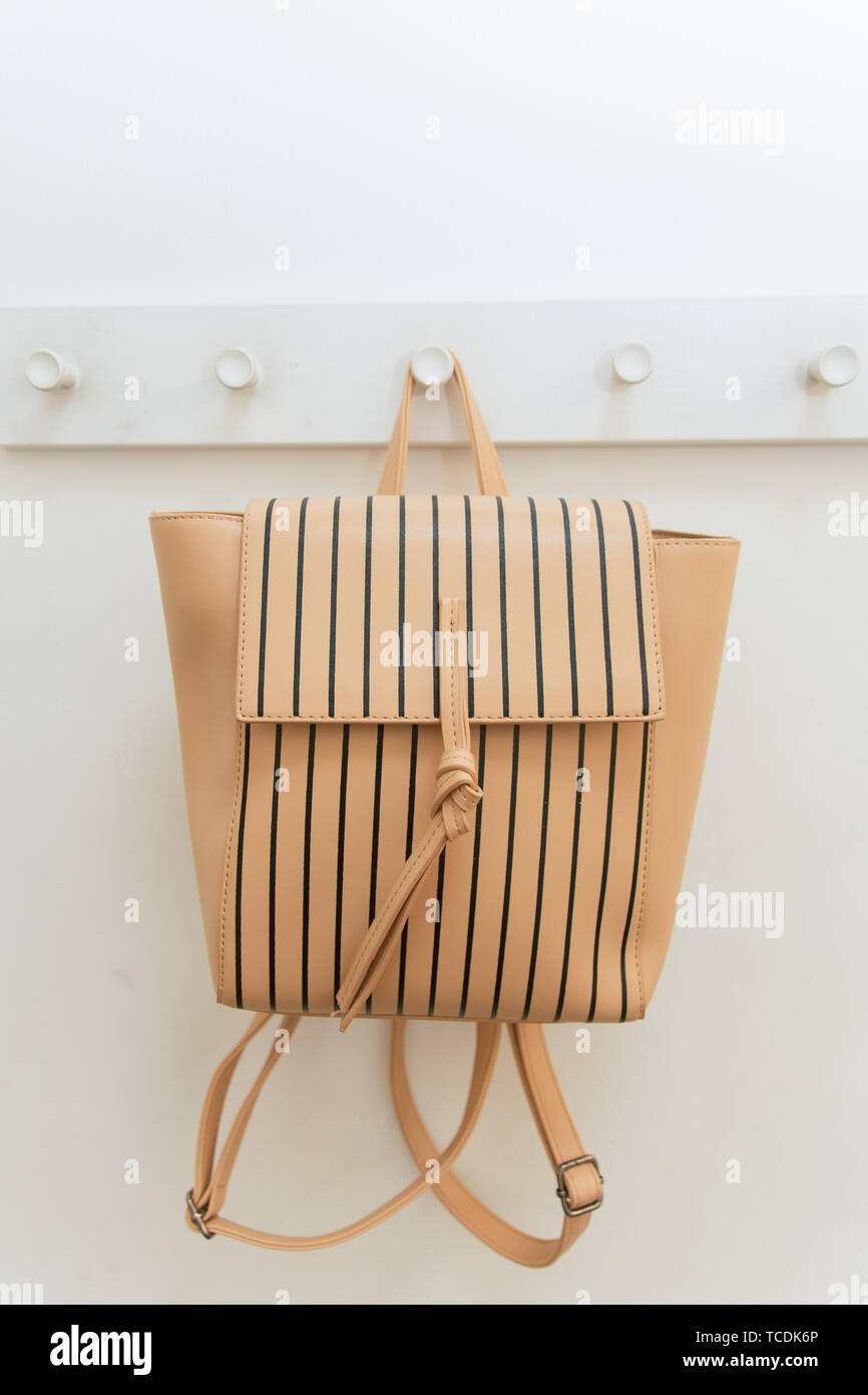 Zaino beige su un appendiabiti in armadio. Uno zaino appeso ad un gancio in  un montaggio del negozio sala. vendita di zaini e borse Foto stock - Alamy