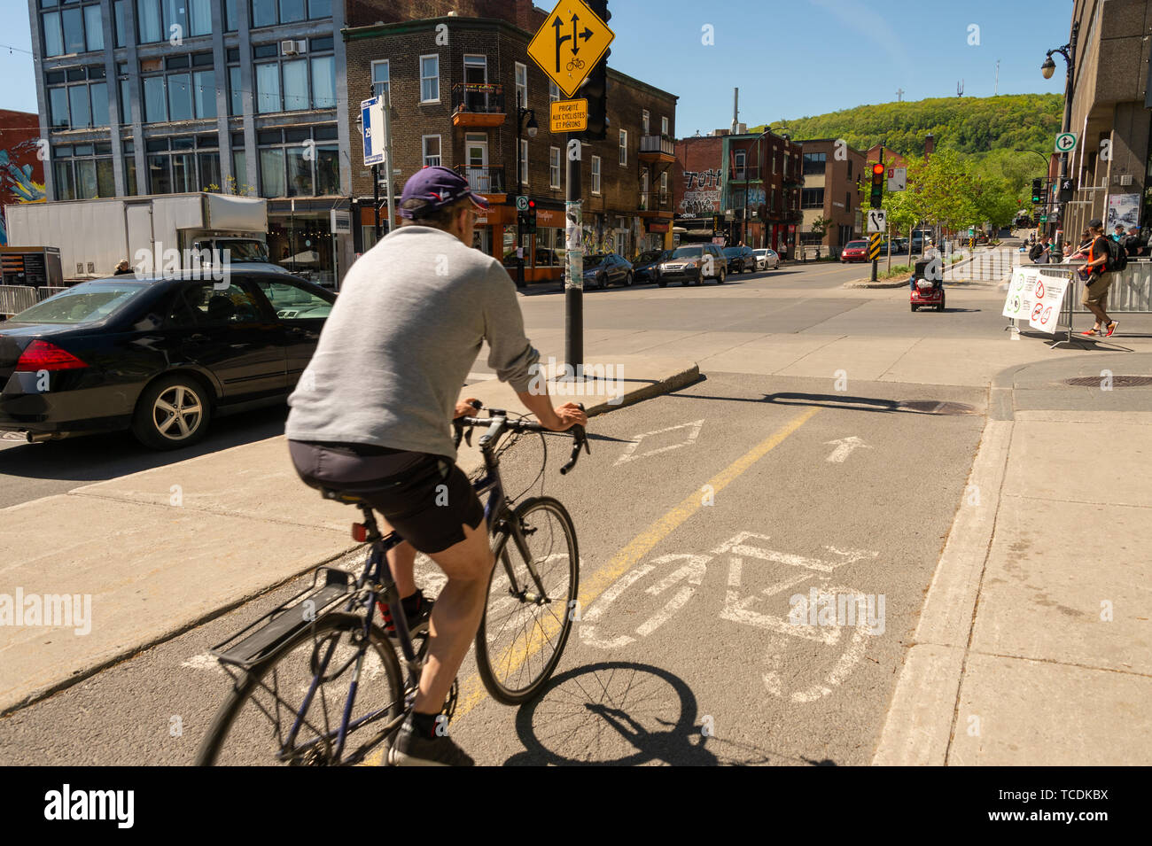 Montreal, Canada - 6 Giugno 2019: un uomo è in sella a una moto su una pista ciclabile su Rachel Street nel quartiere di Plateau. Foto Stock