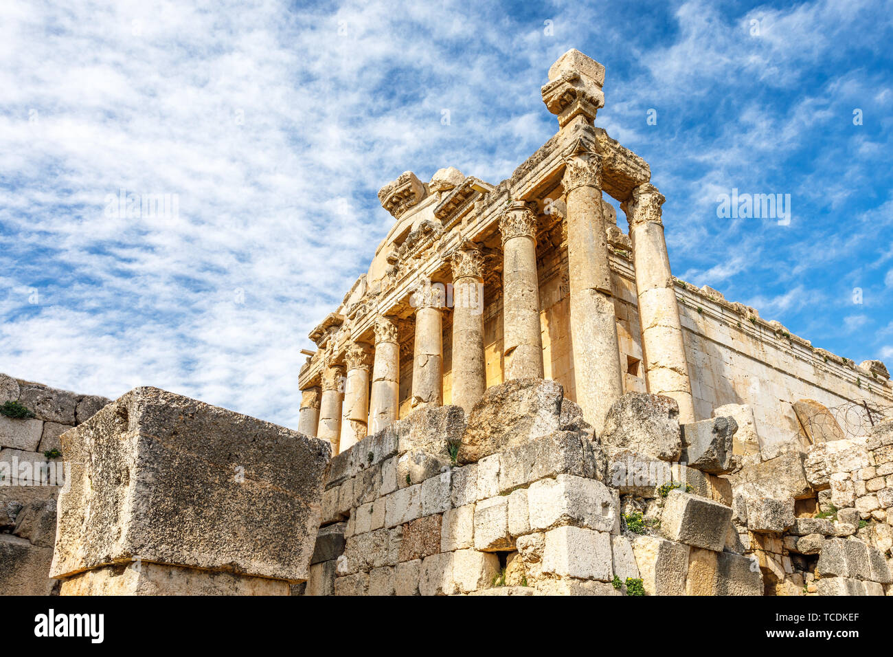 Colonne di antico tempio romano di Bacco con rovine circostanti e cielo blu in background, Beqaa Valley, Baalbeck, Libano Foto Stock