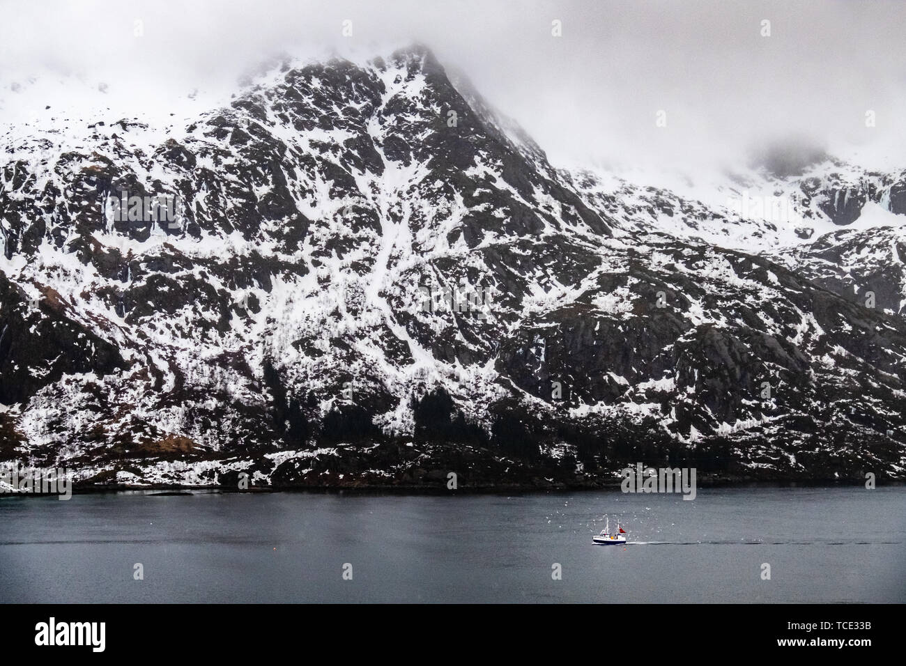 In barca a vela un passato cime di montagna, Lofoten, Nordland, Norvegia Foto Stock