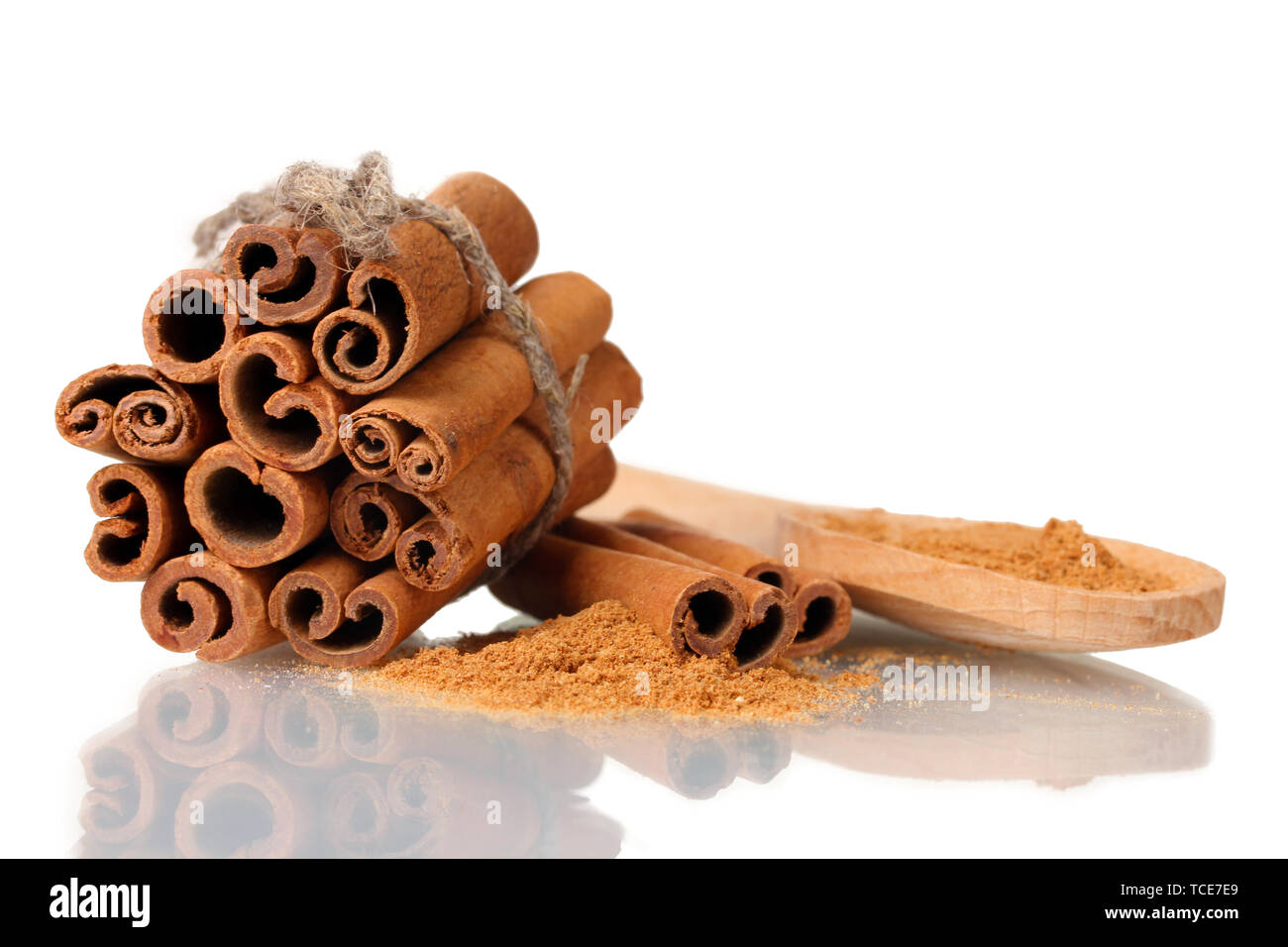 Bastoncini di cannella e polvere in cucchiaio di legno isolato su bianco Foto Stock