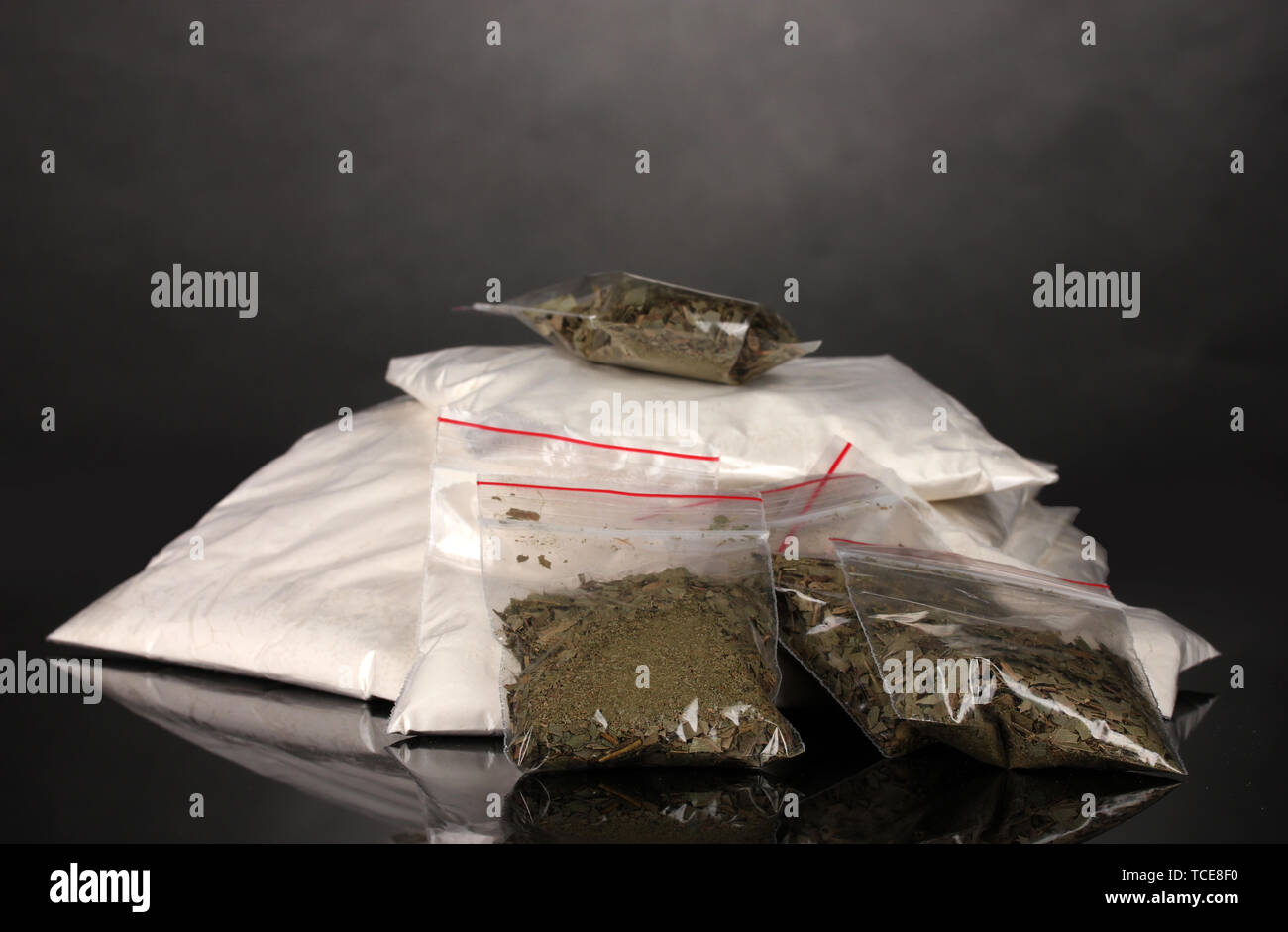 Cocaina e marijuana in pacchetti su uno sfondo grigio Foto Stock