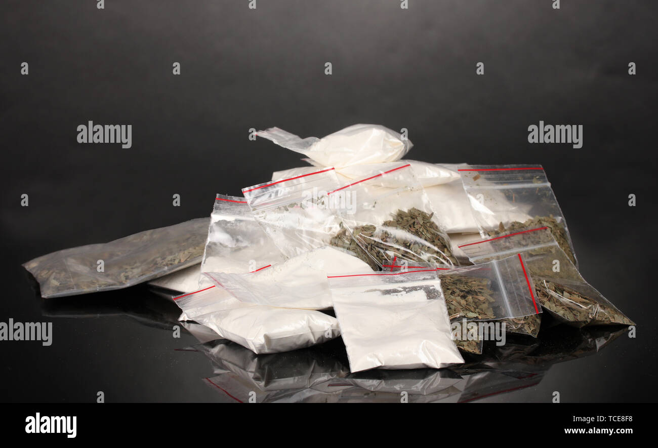 Cocaina e marijuana in pacchetti su uno sfondo grigio Foto Stock